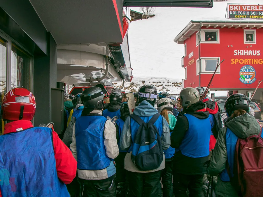 Jugendliche warten im Skiverleih.
